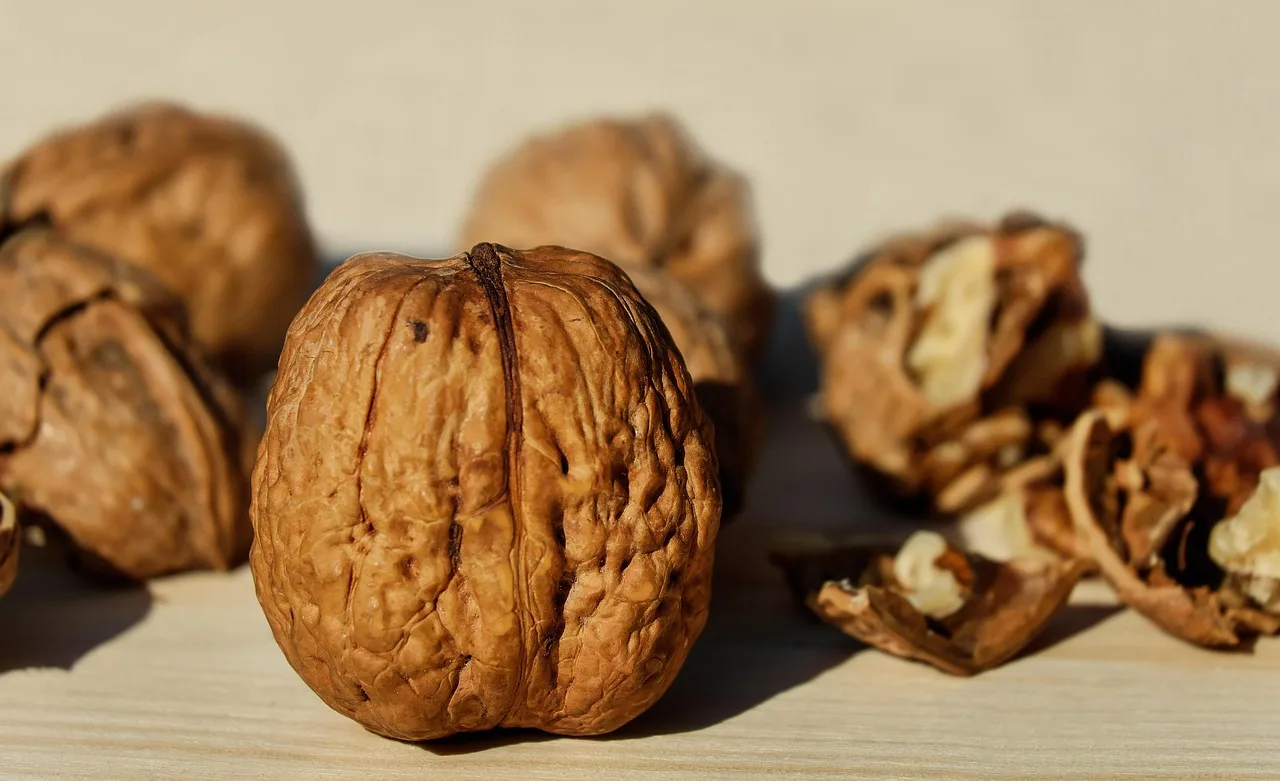 Tre noci su un tavolo, simbolo di un'alimentazione sana per ridurre il colesterolo cattivo.